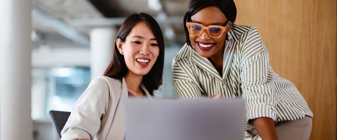 Two women in an office looking at a laptop