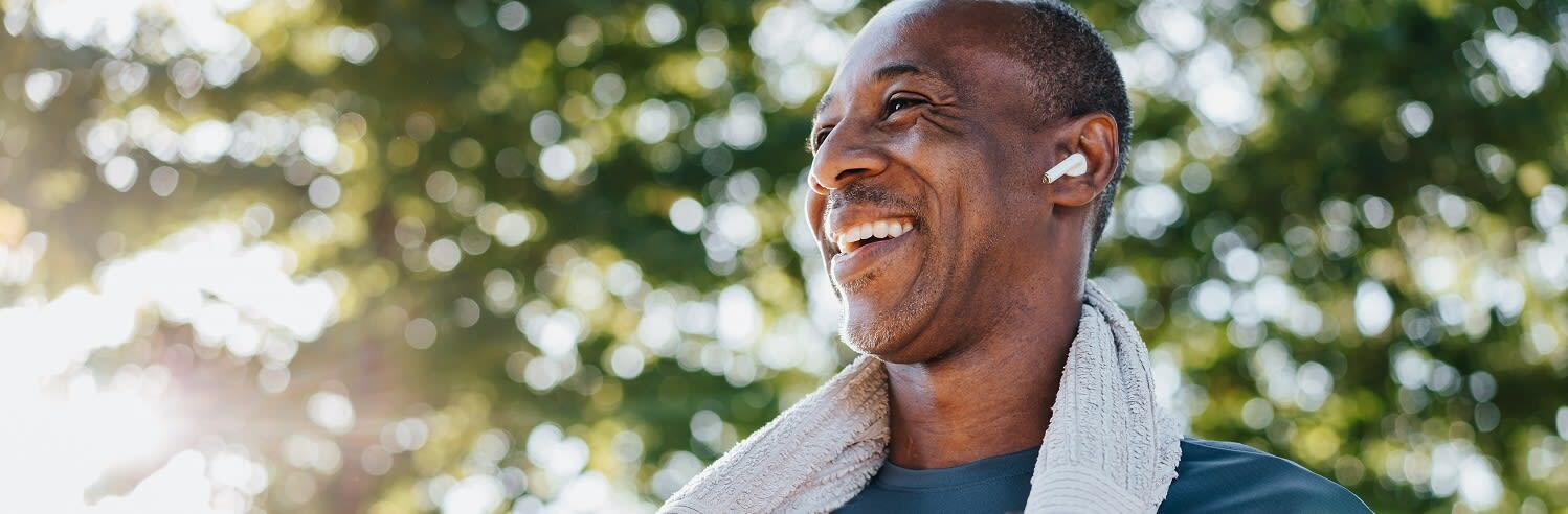 Man met draadloze koptelefoon die glimlacht