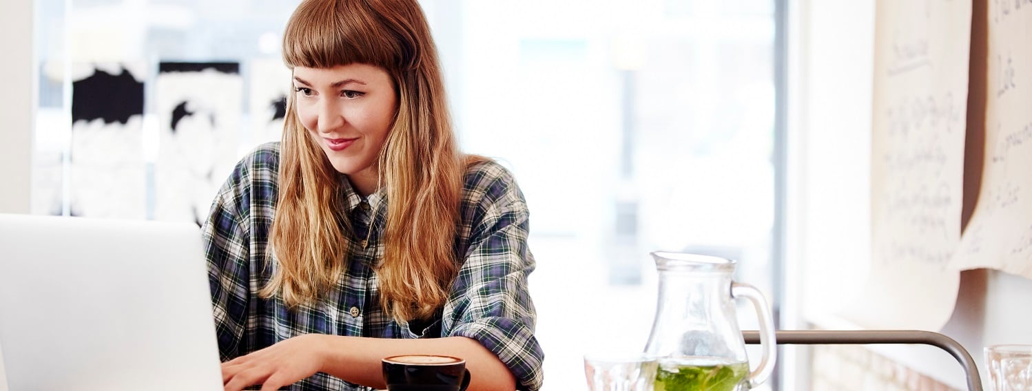Women typing on a laptop at a coffee shop