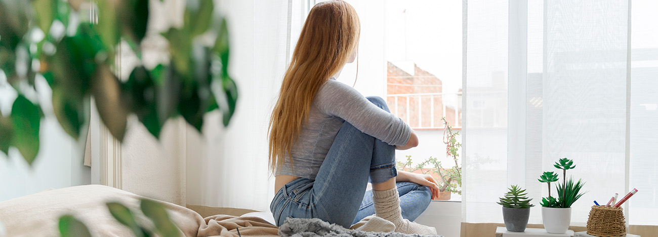 vrouw kijkt uit het raam
