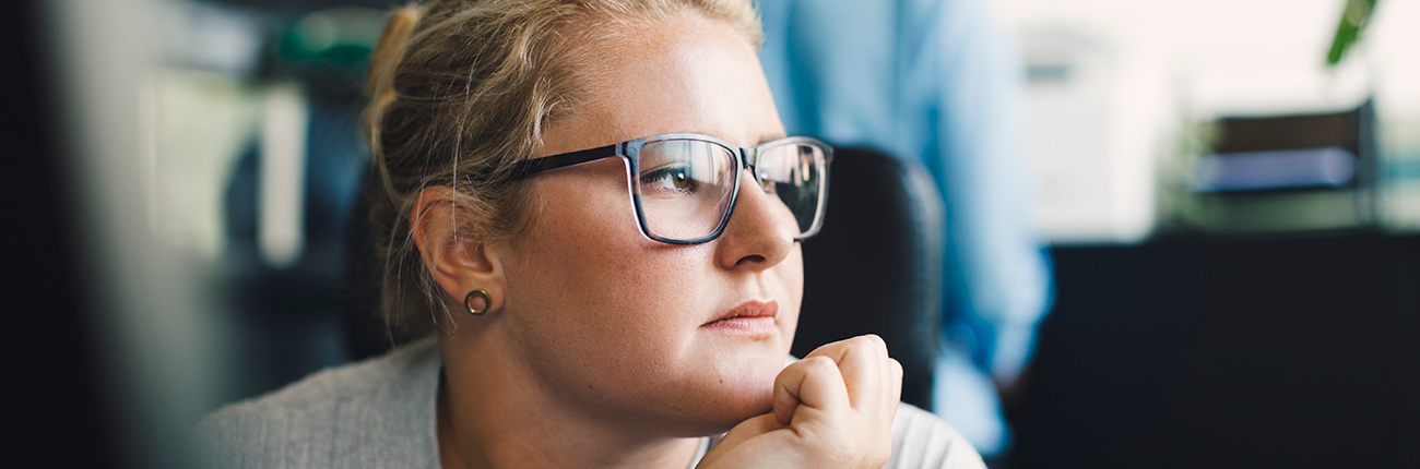 vrouw leunt kin op hand, kijkt naar buiten