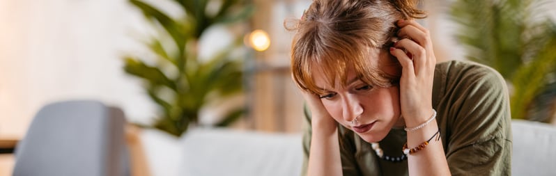 vrouw-zit-neerslachtig-op-de-bank